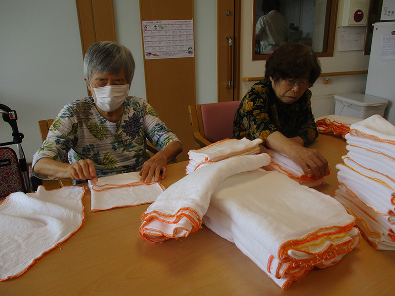 タオルを畳んでいます1 - 小多機まなぐら南